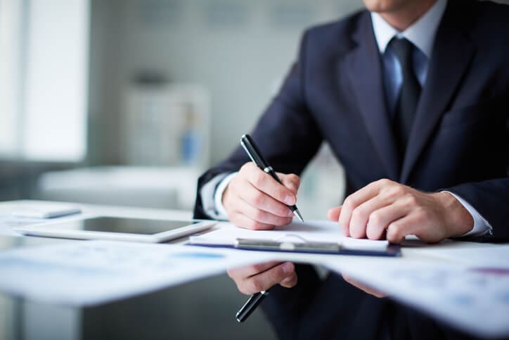 Close-up of male hands with pen over document